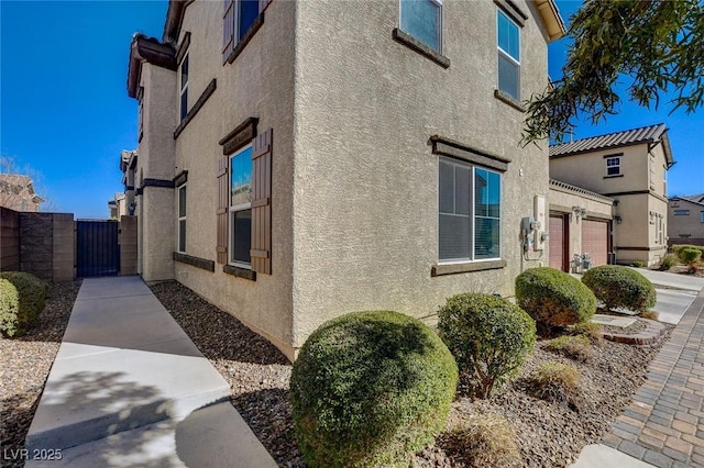 view of home's exterior featuring stucco siding and a gate