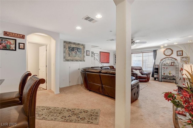 living room with a ceiling fan, visible vents, recessed lighting, arched walkways, and light colored carpet