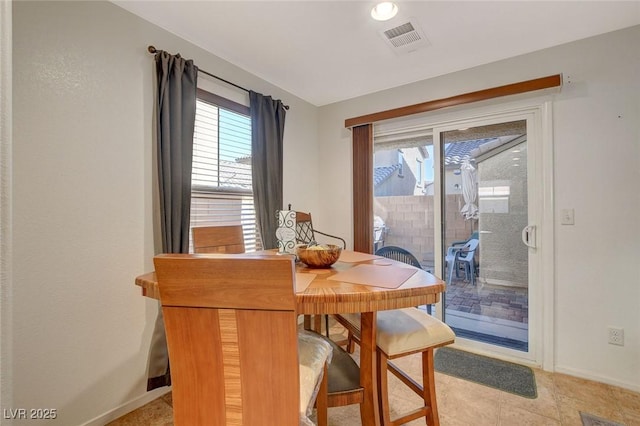 dining area with a wealth of natural light, visible vents, and baseboards