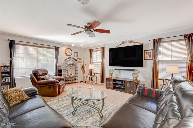 living room with carpet flooring, visible vents, a wealth of natural light, and ceiling fan