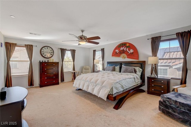 bedroom with carpet flooring, multiple windows, a ceiling fan, and visible vents