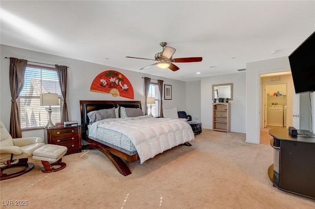 bedroom featuring visible vents, light colored carpet, washer / dryer, and a ceiling fan