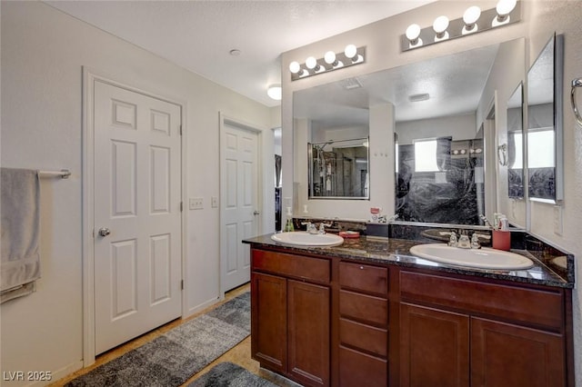 full bath featuring double vanity, an enclosed shower, and a sink