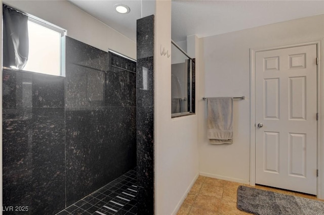 full bath featuring baseboards, walk in shower, and tile patterned flooring