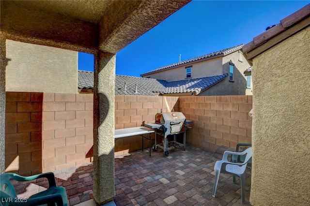 view of patio featuring grilling area and fence