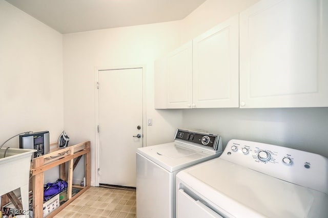 clothes washing area featuring cabinet space and washing machine and clothes dryer