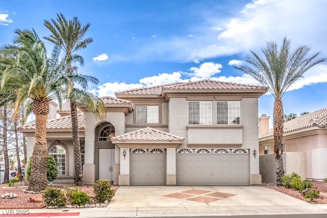 mediterranean / spanish house with a tiled roof, stucco siding, driveway, and a garage