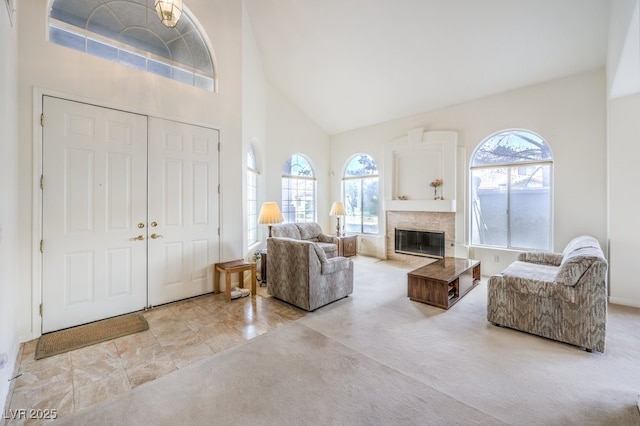 carpeted foyer with a high ceiling, a wealth of natural light, and a premium fireplace