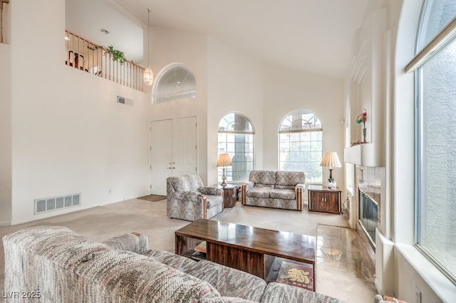 living room featuring visible vents, carpet flooring, and high vaulted ceiling