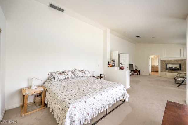 carpeted bedroom featuring visible vents, lofted ceiling, baseboards, and a fireplace with flush hearth