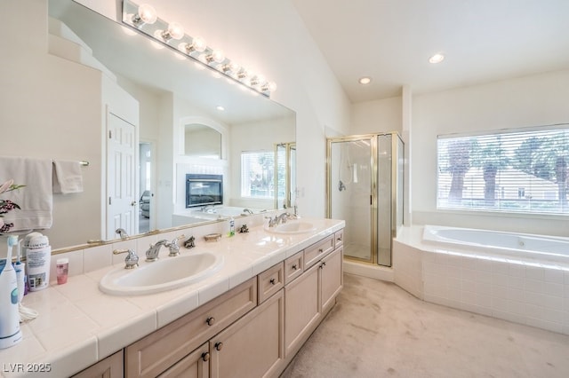 full bath with a bath, a stall shower, double vanity, and a sink