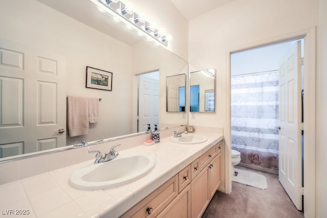 bathroom featuring double vanity, toilet, a tub to relax in, and a sink