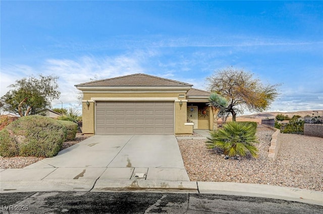 view of front of property featuring stucco siding, an attached garage, driveway, and a tile roof