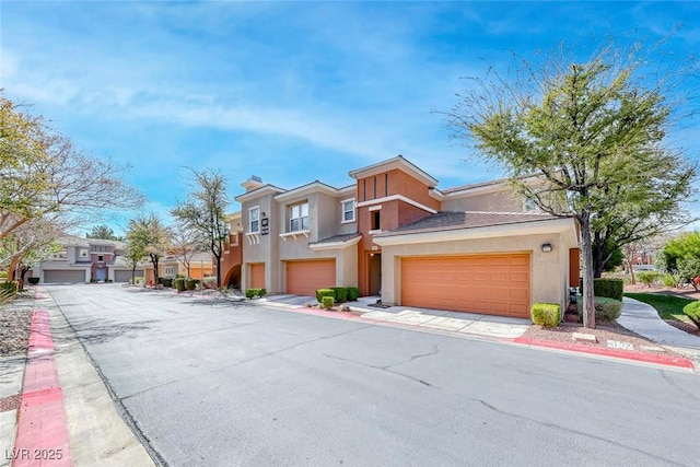 multi unit property featuring a residential view, stucco siding, and a garage