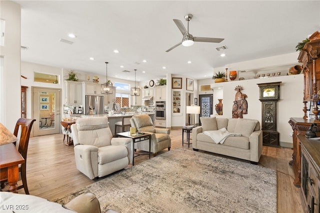 living room with light wood finished floors, visible vents, recessed lighting, and a ceiling fan