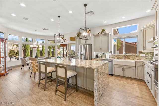 kitchen featuring visible vents, backsplash, stainless steel appliances, and a sink