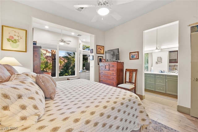 bedroom with baseboards, visible vents, ceiling fan, ensuite bathroom, and light wood-type flooring