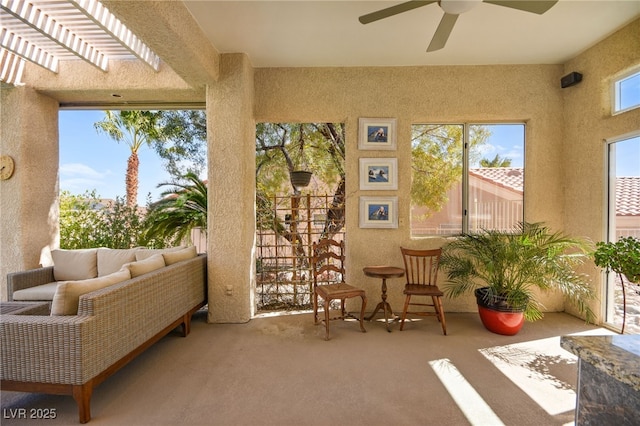 sunroom / solarium featuring a ceiling fan