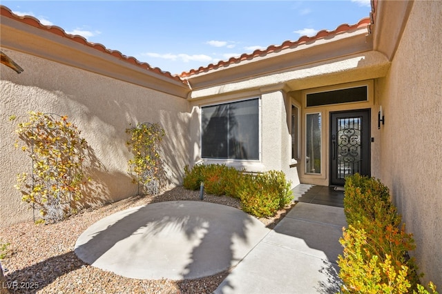 entrance to property featuring stucco siding