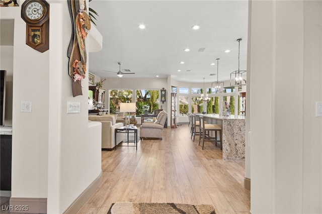 corridor featuring light wood-style flooring and recessed lighting