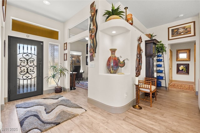 foyer entrance with wood finished floors and baseboards