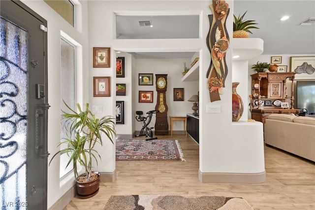 entrance foyer with visible vents, baseboards, and light wood-style flooring