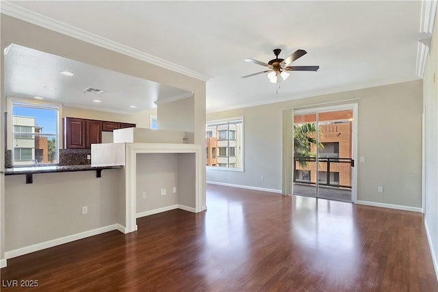 unfurnished living room with dark wood finished floors, a healthy amount of sunlight, visible vents, and baseboards