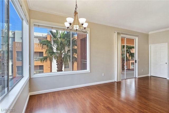 unfurnished room featuring an inviting chandelier, wood finished floors, and crown molding