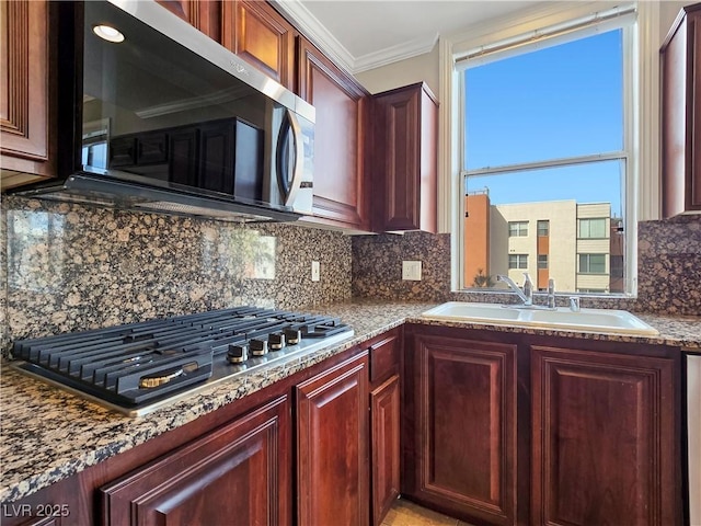 kitchen with ornamental molding, a sink, stainless steel appliances, reddish brown cabinets, and decorative backsplash