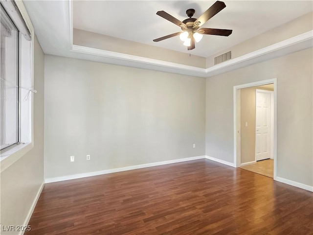 empty room featuring visible vents, ceiling fan, baseboards, and wood finished floors