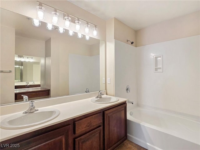 bathroom featuring double vanity, shower / bath combination, and a sink