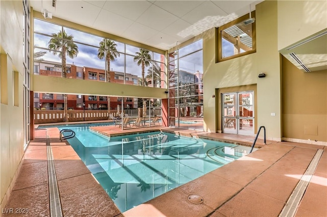 community pool featuring a patio area and glass enclosure