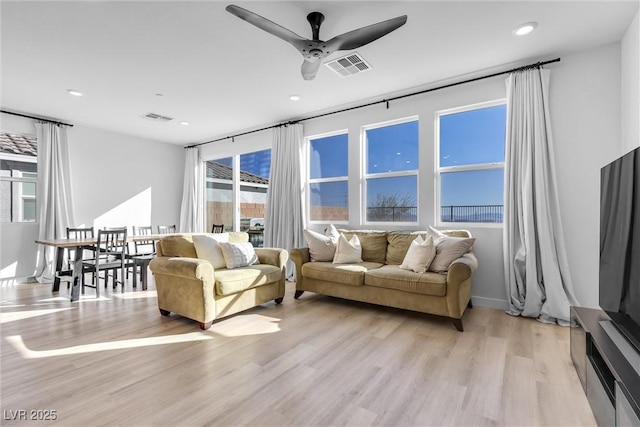 living room with recessed lighting, visible vents, ceiling fan, and light wood-style floors