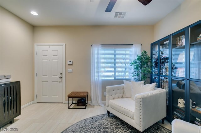 living area with visible vents, ceiling fan, and baseboards