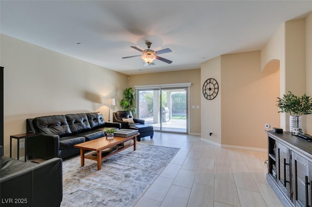 living area featuring baseboards and ceiling fan