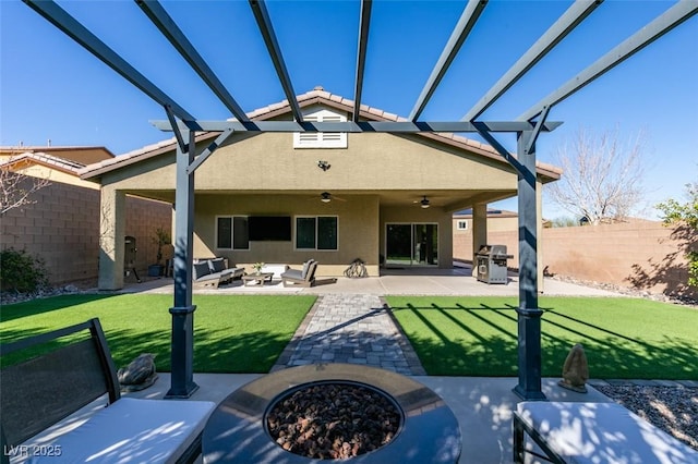 rear view of house featuring stucco siding, an outdoor hangout area, a lawn, and a patio