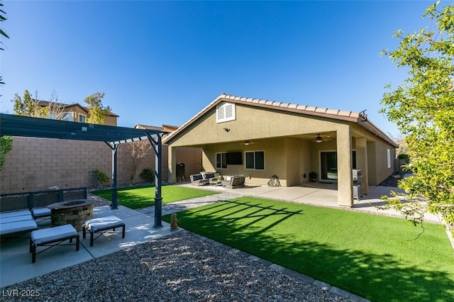 rear view of property featuring a patio, a ceiling fan, a pergola, stucco siding, and a fire pit