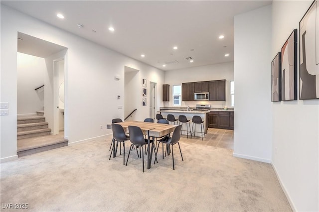 dining space featuring recessed lighting, stairway, and light colored carpet