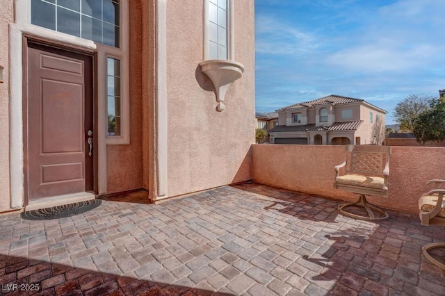 entrance to property featuring a patio area and stucco siding