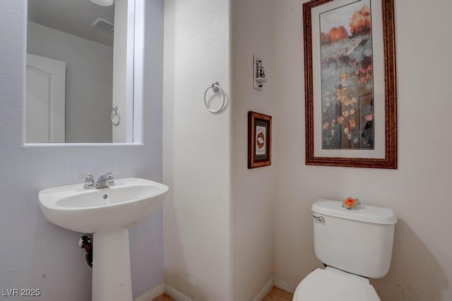 bathroom featuring toilet, baseboards, visible vents, and a sink