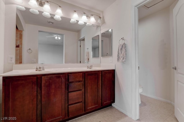 full bath featuring double vanity, toilet, a ceiling fan, and a sink