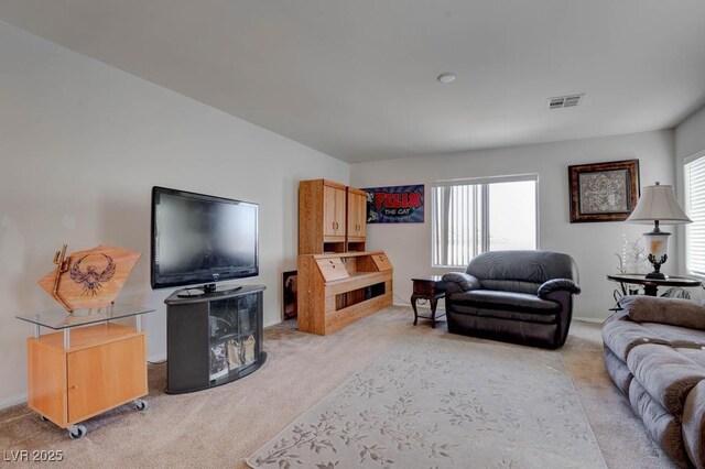 living area with plenty of natural light, light colored carpet, and visible vents