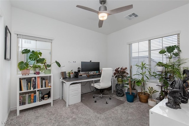 office with a ceiling fan, light colored carpet, and visible vents