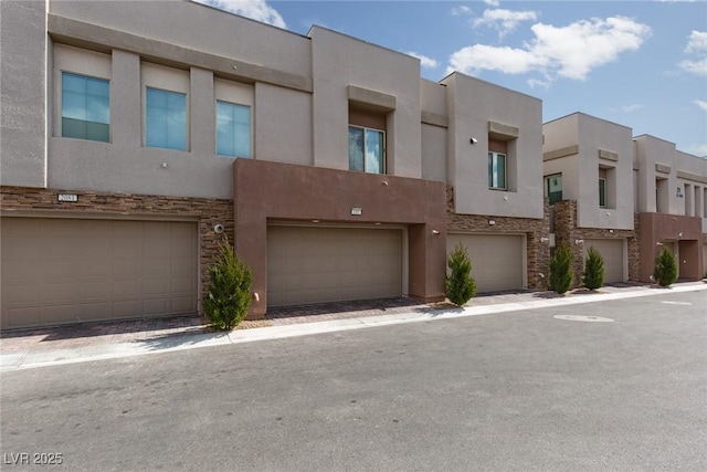 exterior space with stone siding, stucco siding, and a garage