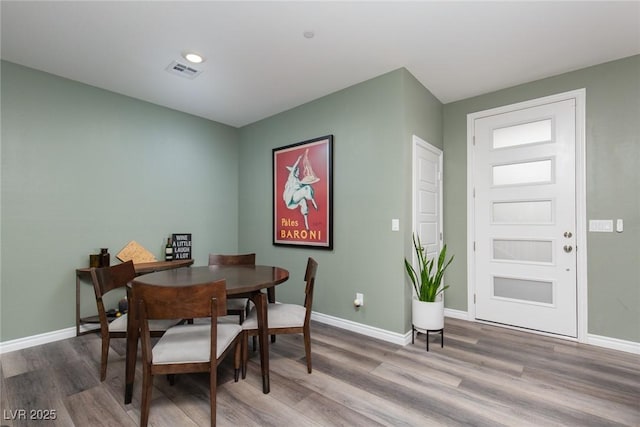 dining area featuring visible vents, baseboards, and wood finished floors