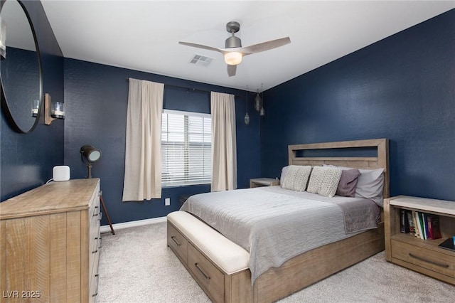 bedroom with ceiling fan, light colored carpet, visible vents, and baseboards