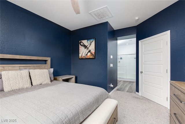 carpeted bedroom with visible vents, connected bathroom, and ceiling fan