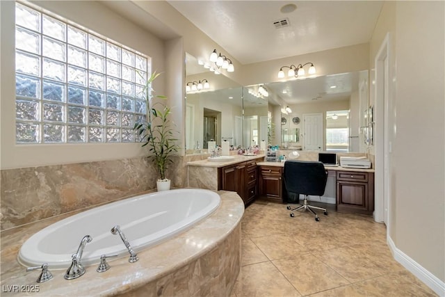 bathroom featuring tile patterned flooring, a garden tub, vanity, and baseboards