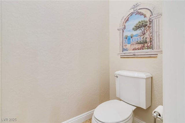 bathroom with baseboards and toilet