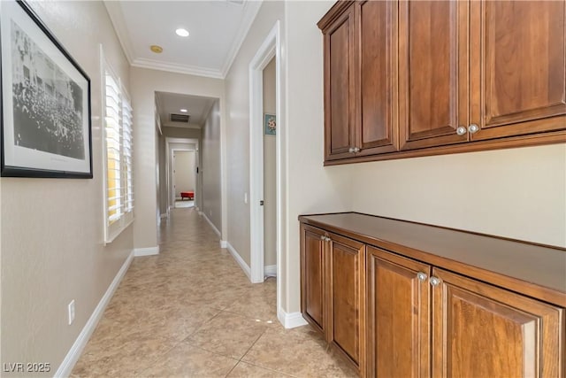 corridor featuring a wealth of natural light, visible vents, baseboards, and crown molding